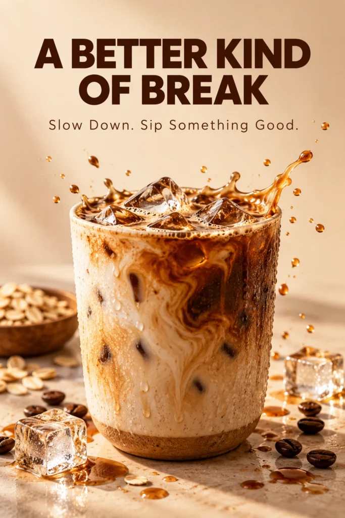 Iced oat-milk coffee in a ceramic cup with a splash beneath “A BETTER KIND OF BREAK,” in warm cream and caramel tones.